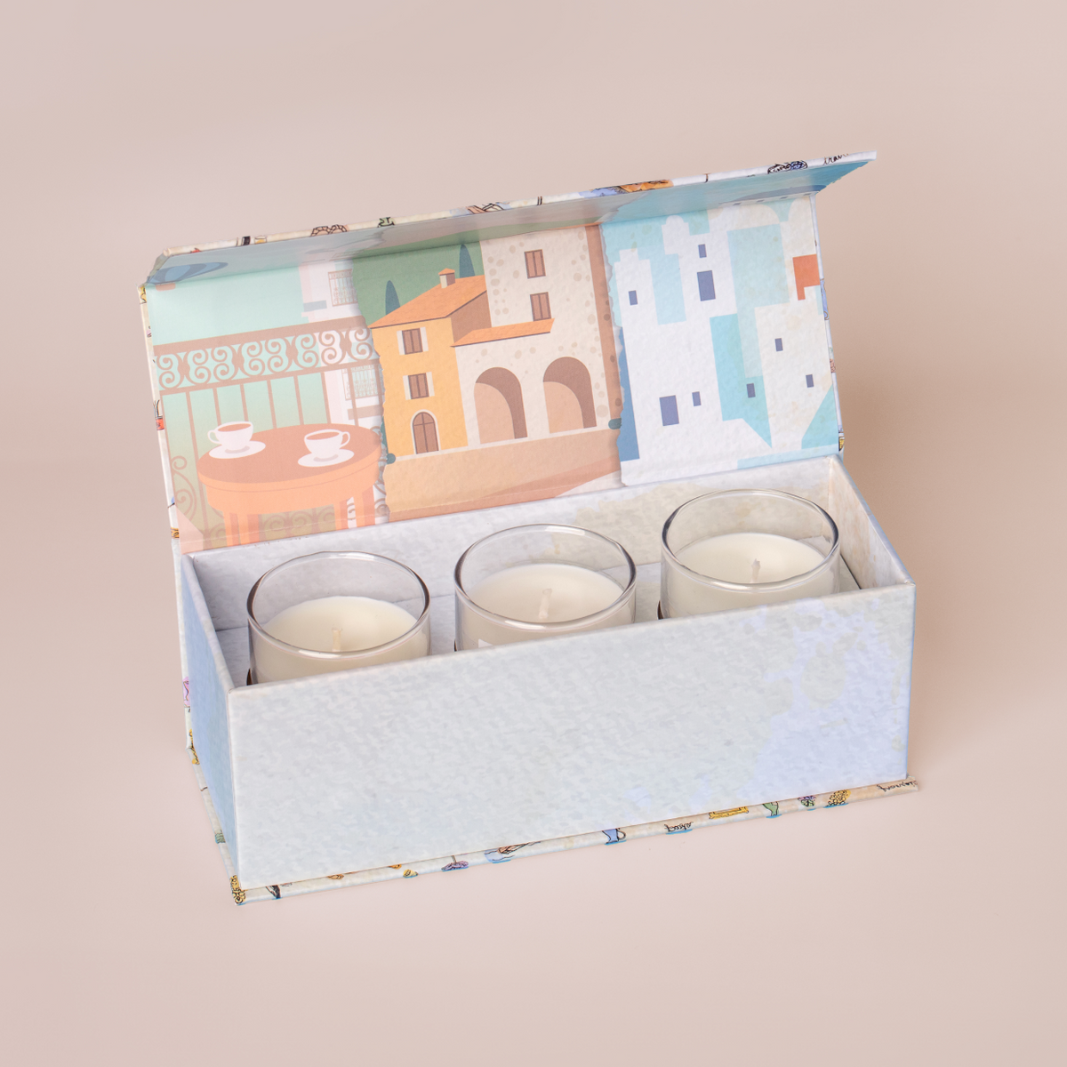 Three mini candles in a box set on a cream background
