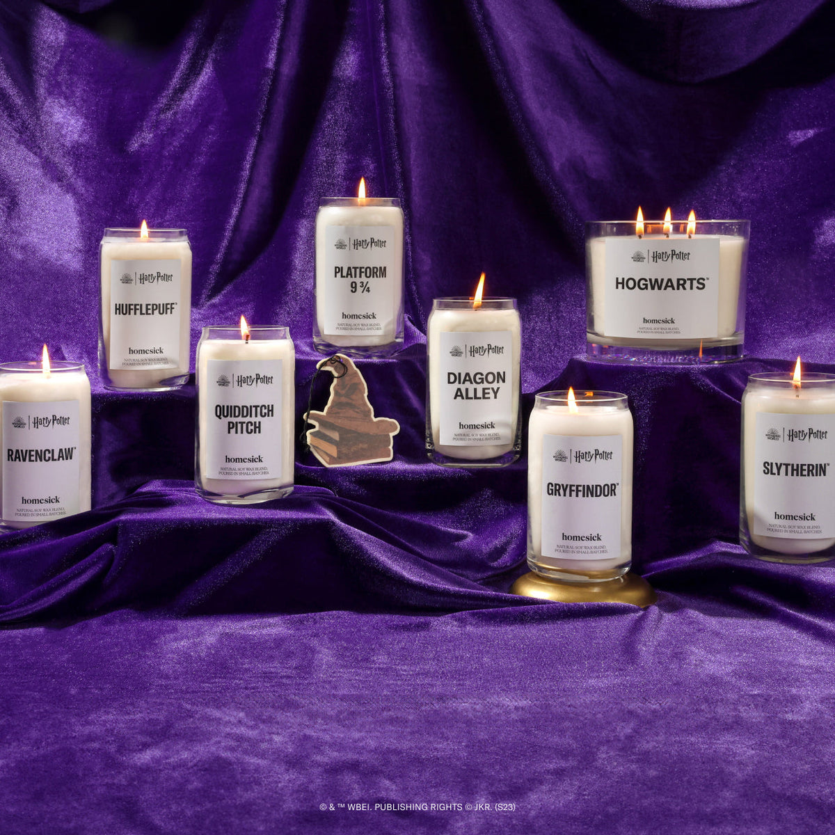 A group shot of all the products part of the Homesick x Harry Potter collaboration. They are shot on a silky purple fabric.